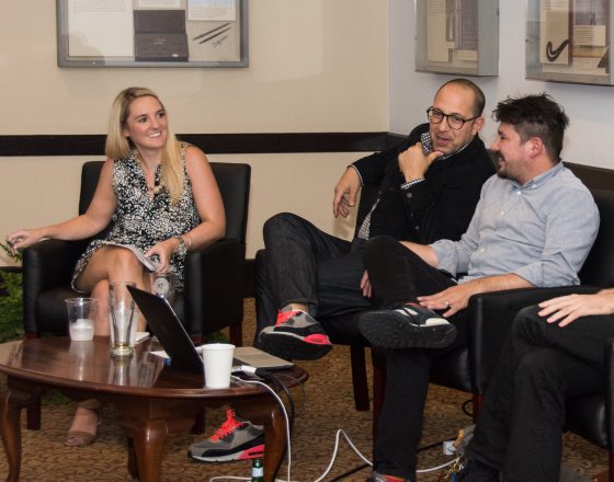 four people sitting in chairs chatting with each other 